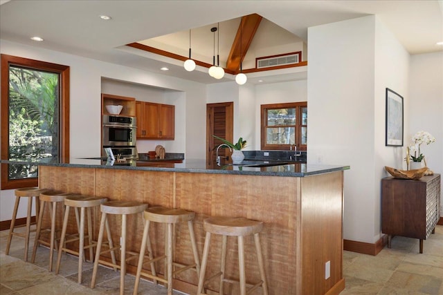 kitchen with a healthy amount of sunlight, hanging light fixtures, and kitchen peninsula