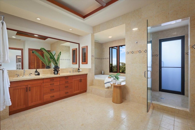 bathroom featuring tile walls, vanity, and shower with separate bathtub