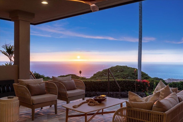 patio terrace at dusk with outdoor lounge area and a water view