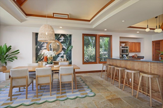 dining space with a tray ceiling and crown molding