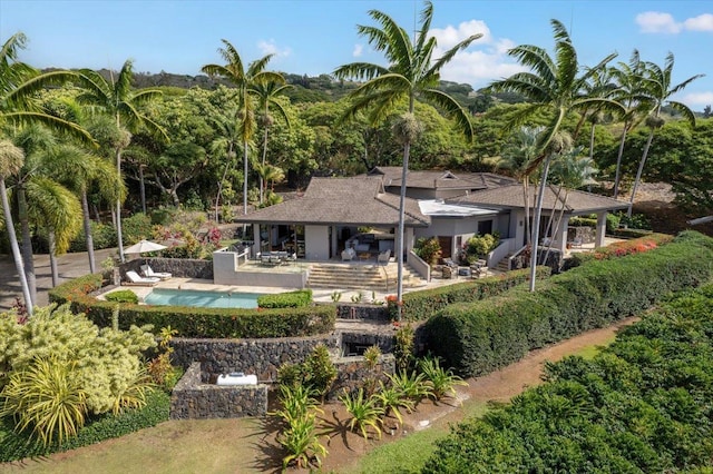 rear view of property with a fireplace and a patio area