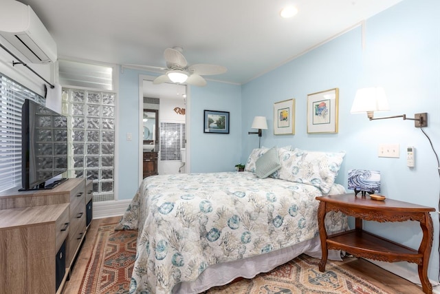 bedroom featuring ceiling fan, light wood-type flooring, and a wall unit AC