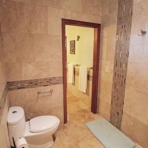 bathroom featuring toilet and tile walls