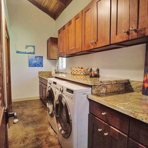 clothes washing area featuring wooden ceiling, cabinets, sink, and washer and dryer