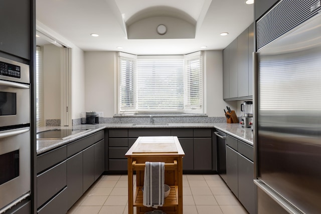 kitchen featuring light tile patterned flooring, appliances with stainless steel finishes, sink, and gray cabinetry