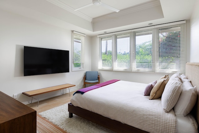 bedroom featuring light tile patterned flooring, ceiling fan, ornamental molding, and a raised ceiling