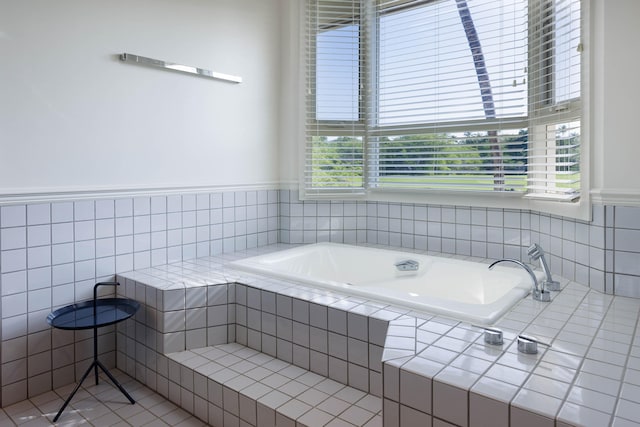 bathroom with tiled tub and tile patterned floors