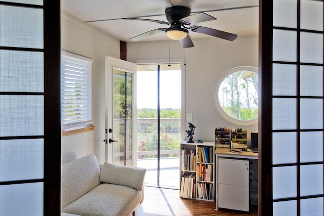 living area featuring light wood-type flooring, a wealth of natural light, and ceiling fan