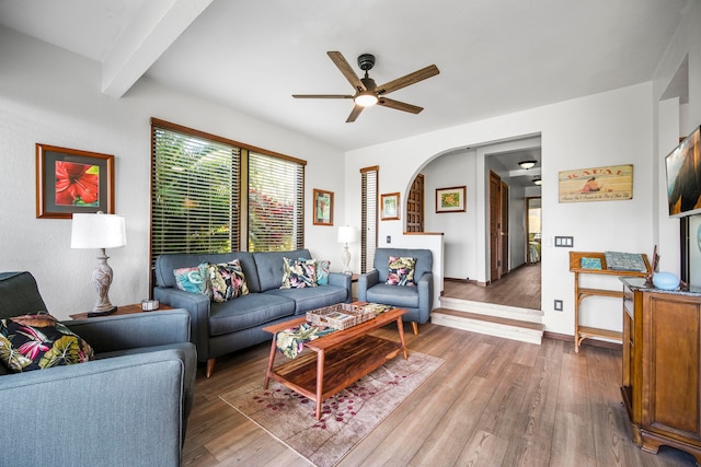 living room featuring hardwood / wood-style floors, beamed ceiling, and ceiling fan