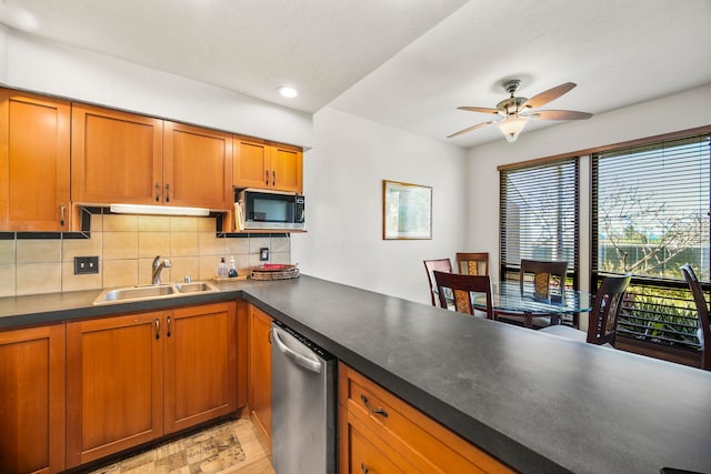 kitchen featuring tasteful backsplash, dishwasher, sink, and ceiling fan