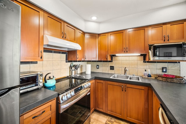 kitchen with appliances with stainless steel finishes, sink, and backsplash