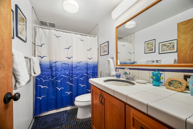 bathroom featuring vanity, tile patterned floors, and toilet