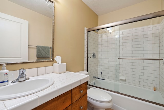 full bathroom with vanity, a textured ceiling, shower / bath combination with glass door, and toilet