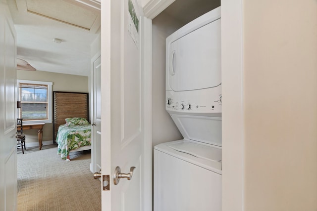 laundry area featuring stacked washer / drying machine