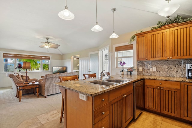 kitchen featuring sink, decorative light fixtures, vaulted ceiling, and a kitchen bar