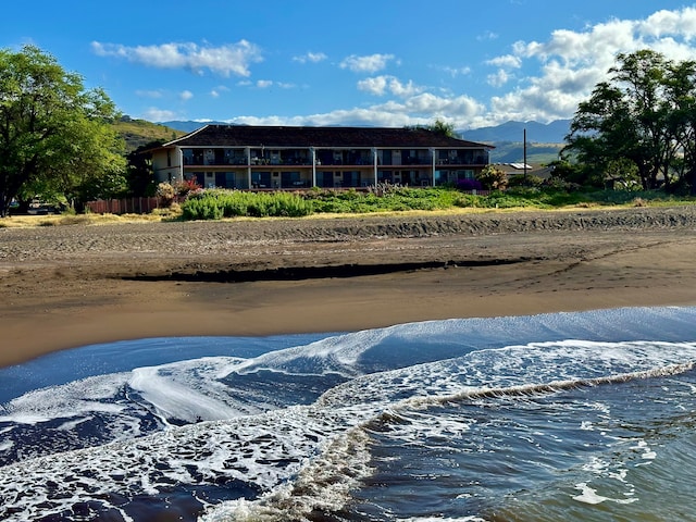 view of water feature with a mountain view and a view of the beach