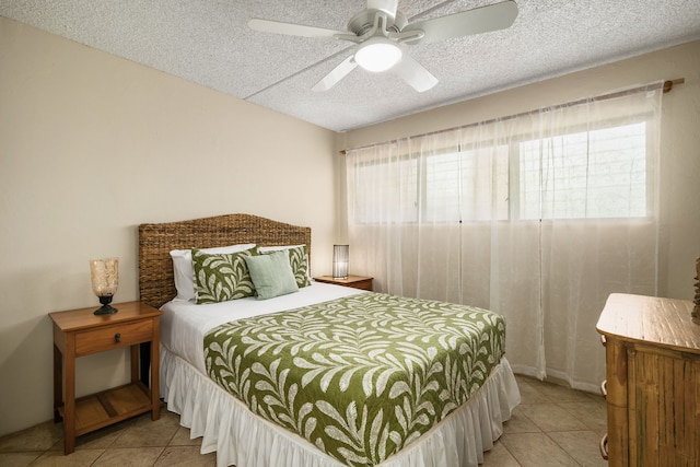 tiled bedroom featuring ceiling fan and a textured ceiling