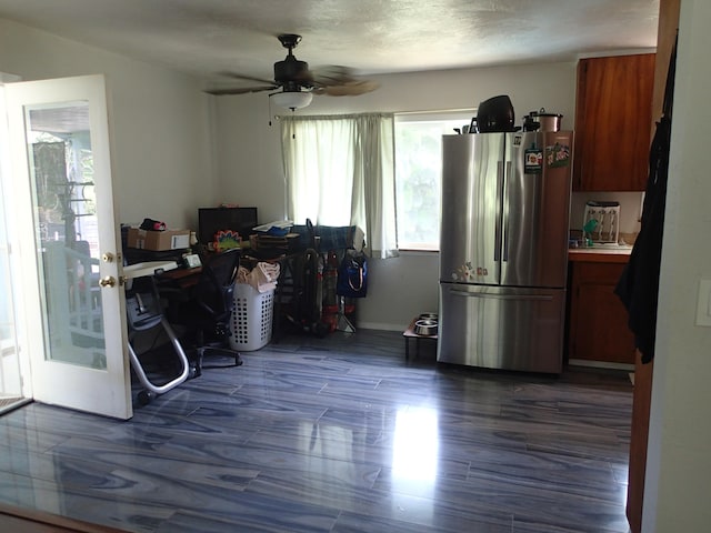 interior space featuring dark wood-type flooring, stainless steel fridge, and ceiling fan