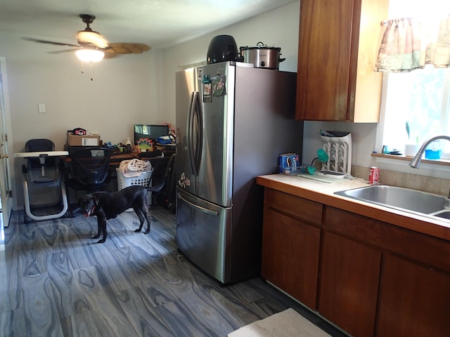 kitchen featuring stainless steel refrigerator, ceiling fan, wood-type flooring, and sink