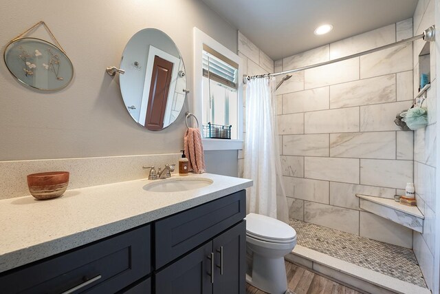 bathroom featuring toilet, vanity, a shower with curtain, and hardwood / wood-style floors