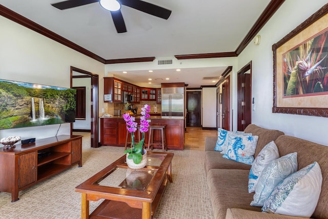 living room with ornamental molding and ceiling fan