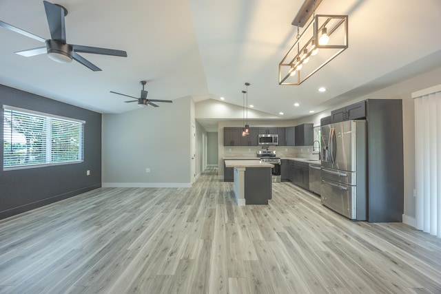 kitchen featuring lofted ceiling, light hardwood / wood-style floors, a center island, hanging light fixtures, and stainless steel appliances