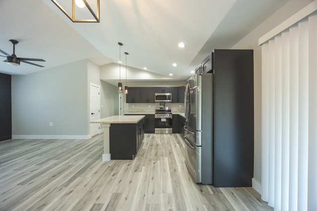 kitchen with pendant lighting, appliances with stainless steel finishes, a center island, vaulted ceiling, and ceiling fan