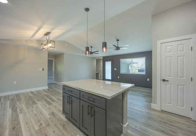 kitchen with pendant lighting, a center island, light hardwood / wood-style floors, vaulted ceiling, and ceiling fan