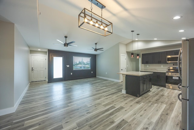 kitchen featuring appliances with stainless steel finishes, pendant lighting, light hardwood / wood-style floors, and a center island