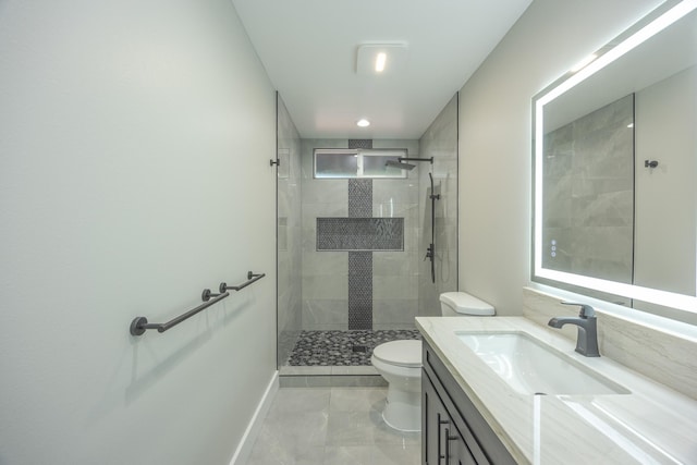 bathroom featuring toilet, vanity, and a tile shower