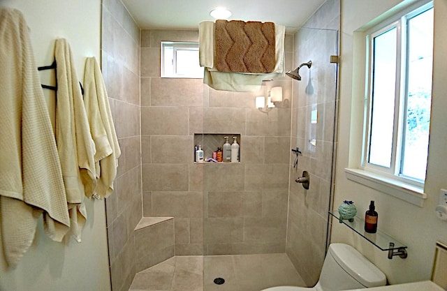 bathroom with toilet and tiled shower