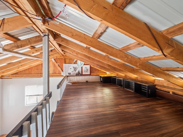 bonus room with dark hardwood / wood-style flooring, vaulted ceiling, and wood walls