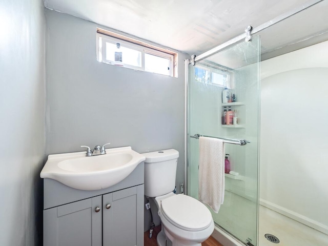 bathroom featuring vanity, an enclosed shower, and toilet