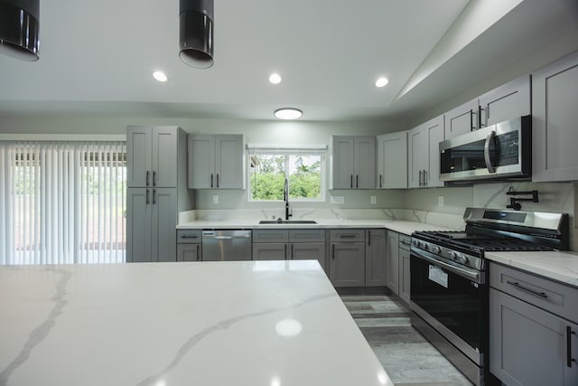 15-1836 11th Ave, Keaau, HI 96749 - kitchen featuring a sink, light stone counters, vaulted ceiling, gray cabinetry, and appliances with stainless steel finishes