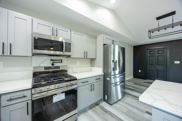 15-1836 11th Ave, Keaau, HI 96749 - kitchen featuring stainless steel appliances, vaulted ceiling, light wood-style flooring, light stone countertops, and baseboards