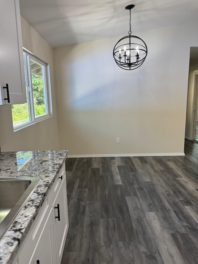 unfurnished dining area featuring dark hardwood / wood-style flooring and a notable chandelier