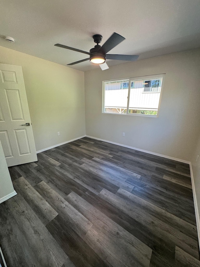 spare room with ceiling fan and dark wood-type flooring