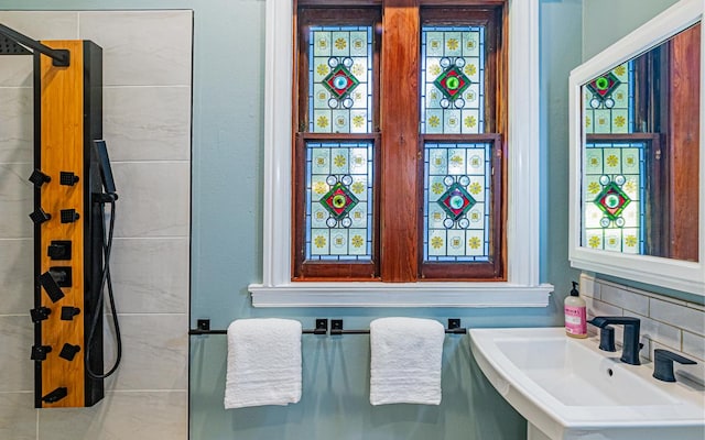 bathroom with sink, backsplash, and a shower