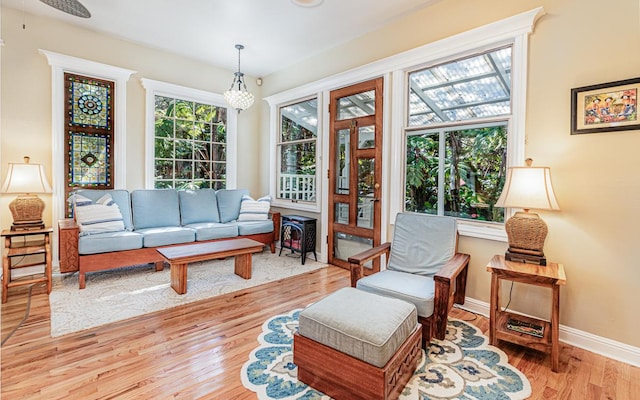 living area featuring a chandelier, light hardwood / wood-style floors, and a wood stove