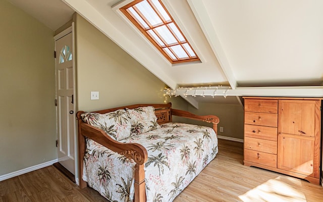 bedroom featuring hardwood / wood-style flooring and vaulted ceiling with skylight