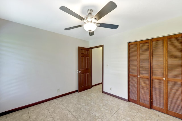 unfurnished bedroom with ceiling fan and a closet