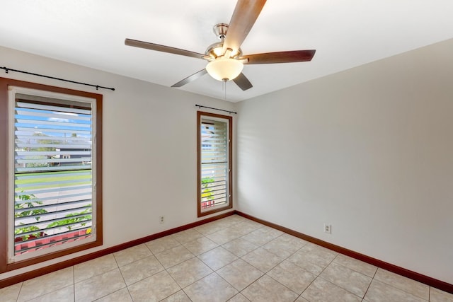 empty room with ceiling fan and light tile patterned floors