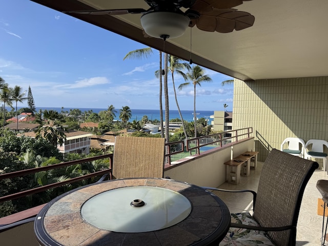 balcony with ceiling fan and a water view