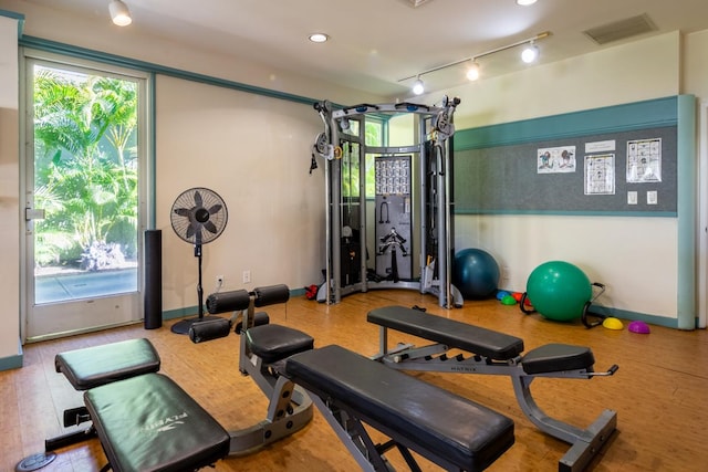 exercise room with plenty of natural light and track lighting