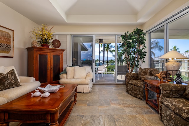 living room featuring a healthy amount of sunlight and a raised ceiling