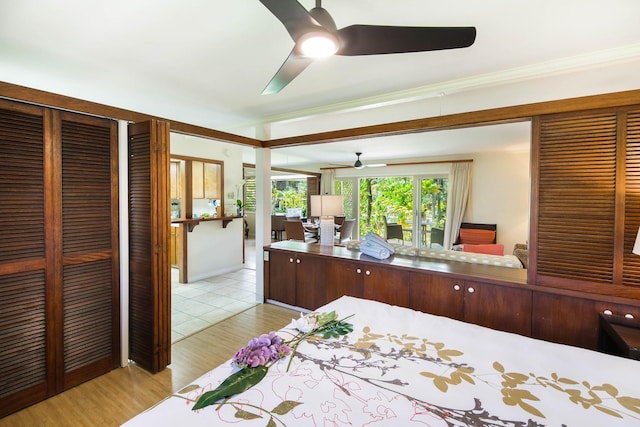 bedroom with ceiling fan, a closet, ornamental molding, and light hardwood / wood-style flooring