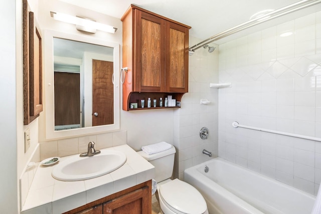 full bathroom featuring toilet, tiled shower / bath, vanity, and tasteful backsplash