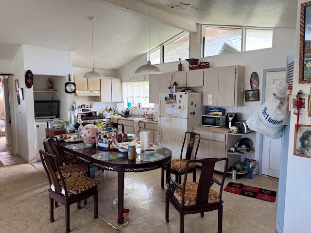 dining room featuring vaulted ceiling with beams