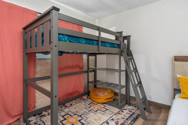 bedroom with a textured ceiling and dark wood-type flooring