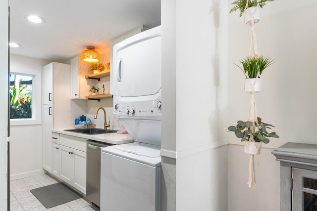 clothes washing area with sink and stacked washer and dryer